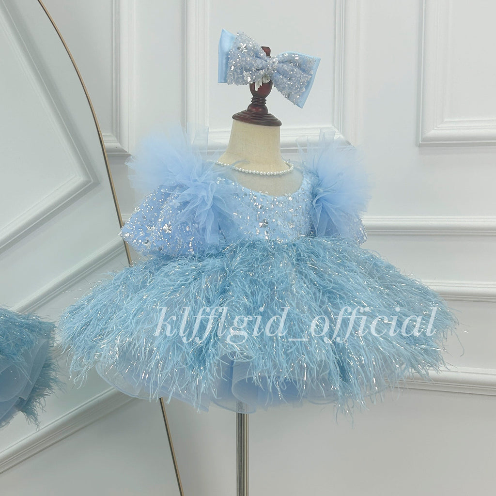 Angled side view of baby blue girls feather-effect princess dress with sparkling bodice, pearl neckline and voluminous skirt