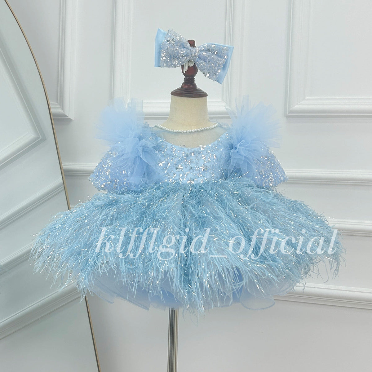 Baby blue girls princess dress with sparkling sequin bodice, pearl neckline, puff sleeves and fluffy feather-effect tutu skirt