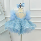 Back view of baby blue girls princess dress featuring a heart-shaped open back, pearl trim, puff sleeves and feather-effect skirt
