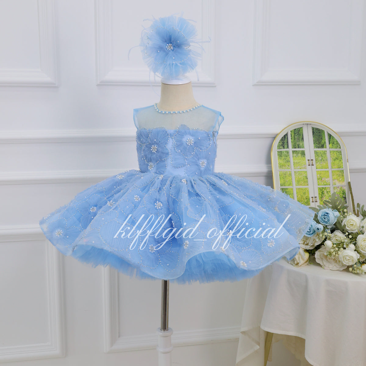 Baby blue girls birthday princess dress with floral embellishments, pearl-like neckline and a full sparkling tulle skirt front view