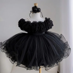 Black princess party dress for girls featuring large fabric flowers across the bodice, a matching floral headpiece, and a dramatic full tulle skirt.