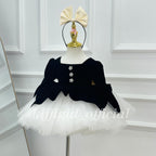 Front view of a black velvet princess dress with a scalloped bodice hem and a voluminous white tutu skirt.