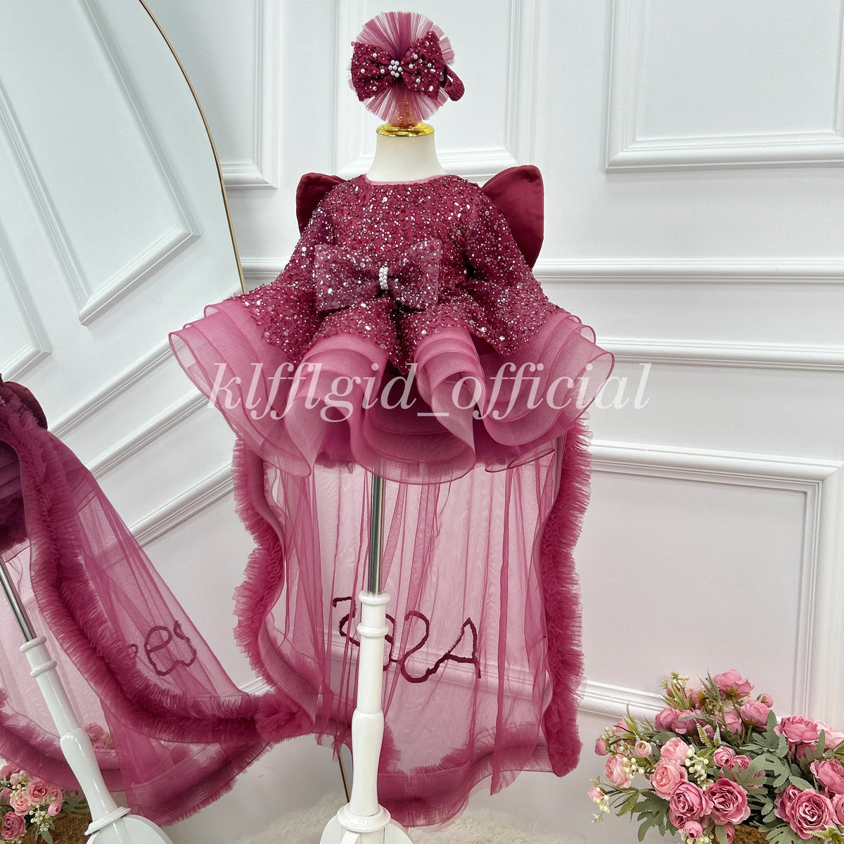 Burgundy butterfly-themed party dress for girls with sparkling sequin fabric, puffed shoulder accents, a decorative bow, a voluminous pink-burgundy skirt, and long sheer trailing panels.