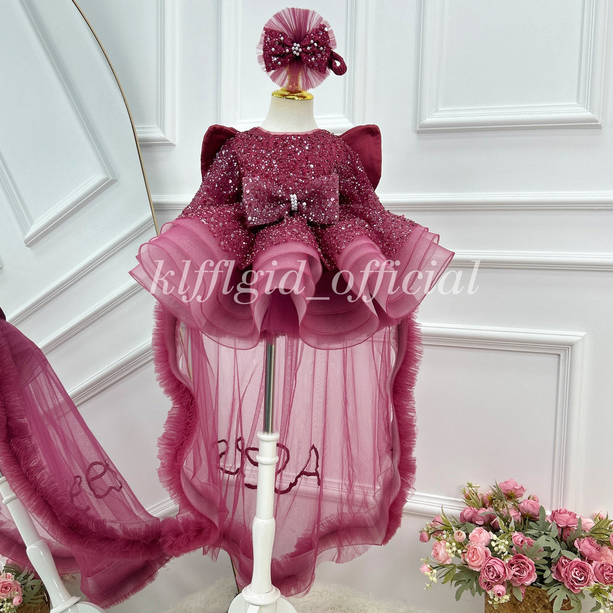 Front view of a burgundy girls' butterfly wing birthday dress with sparkling sequin embellishments, puffed shoulders, a decorative waist bow, and a layered tulle skirt with long sheer panels.