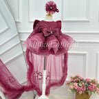 Close front view of a burgundy sequin tulle princess dress with a glittering bodice, oversized waist bow, sculpted layered skirt, and floor-length sheer tulle panels.