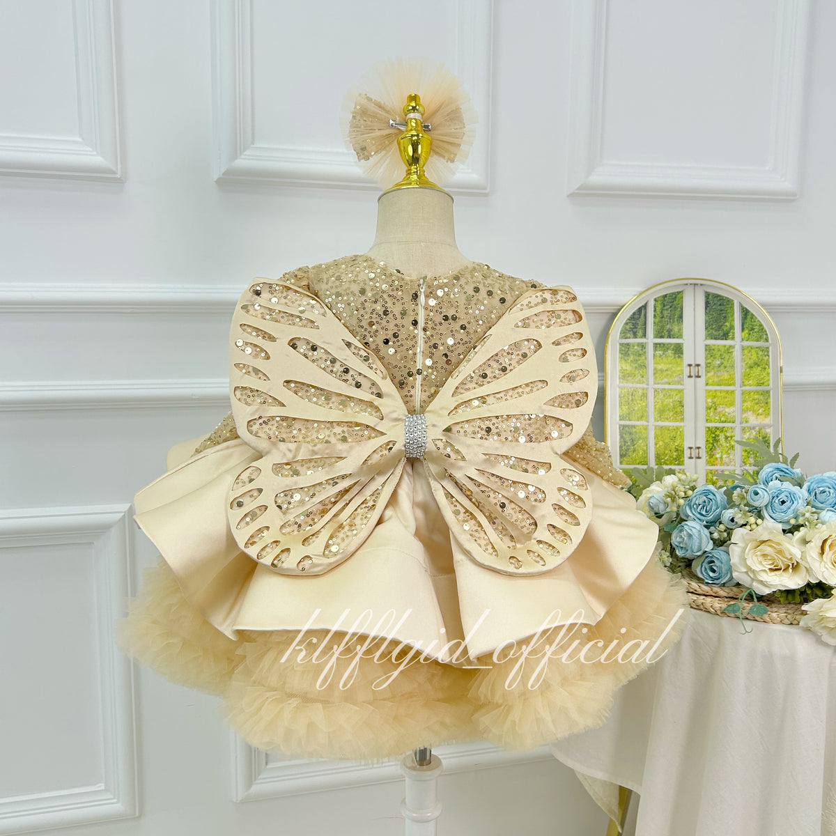 Champagne girls princess dress featuring a large embellished butterfly bow on the back