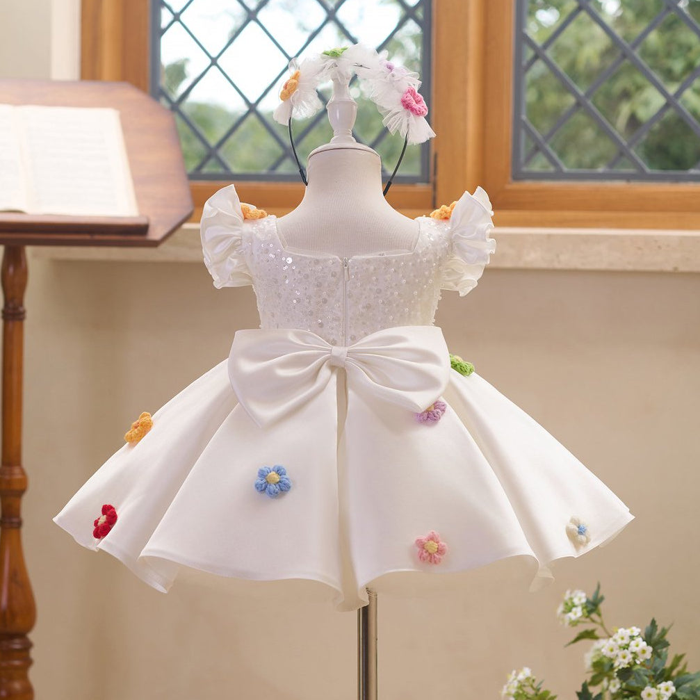 Back view of white girls princess dress with large bow and floral appliques