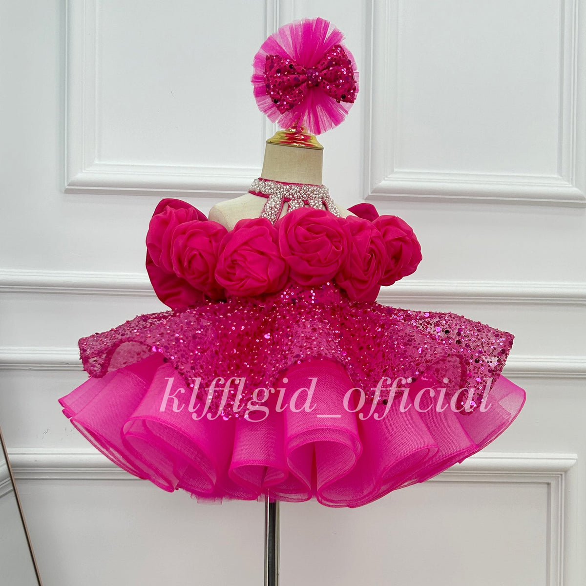 Hot pink princess dress showing its extended sheer tulle train, ruffled pink edging, and small butterfly embellishments.