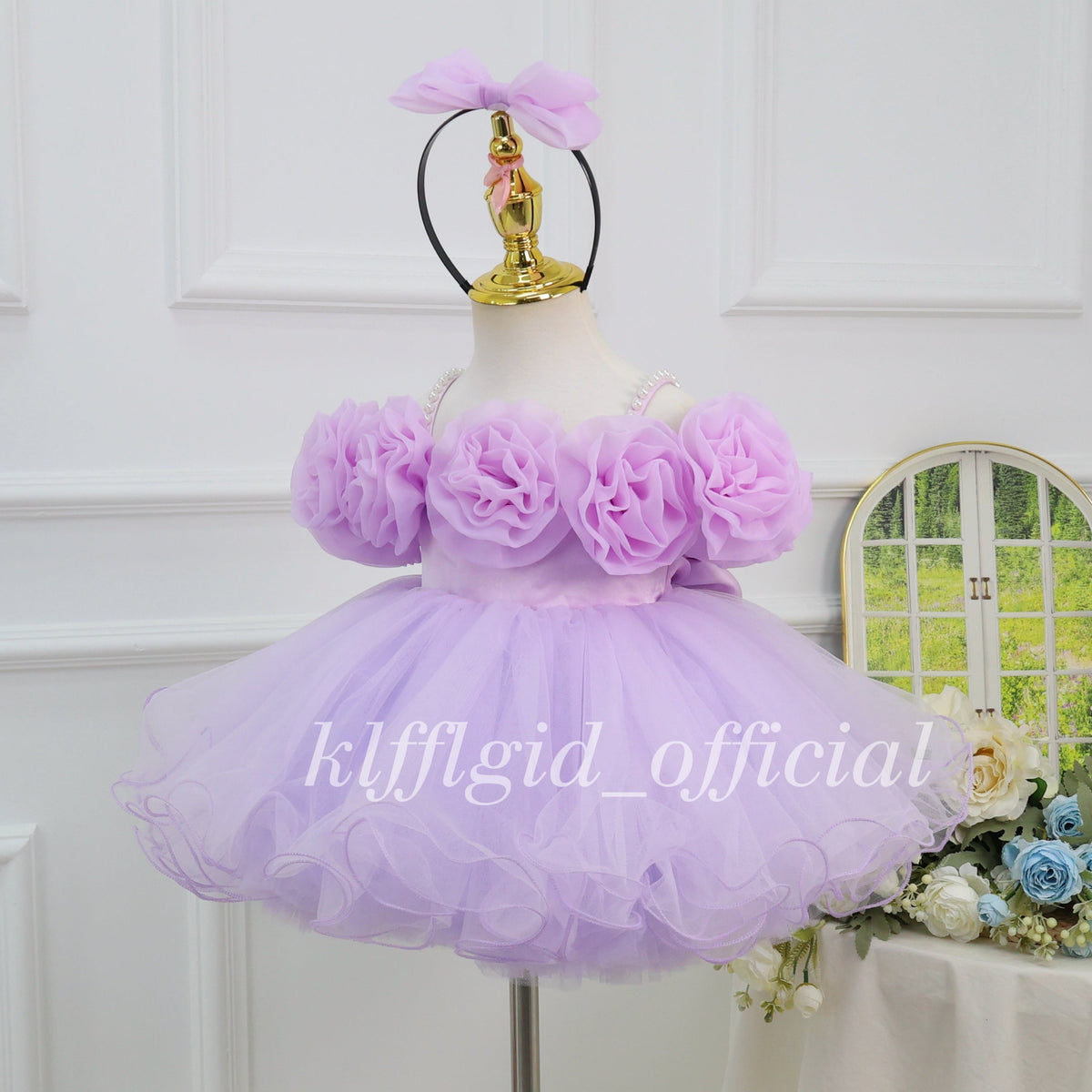 Angled view of a lavender princess dress for girls with dimensional floral decorations, a voluminous tulle skirt, and delicate ruffled hem details.