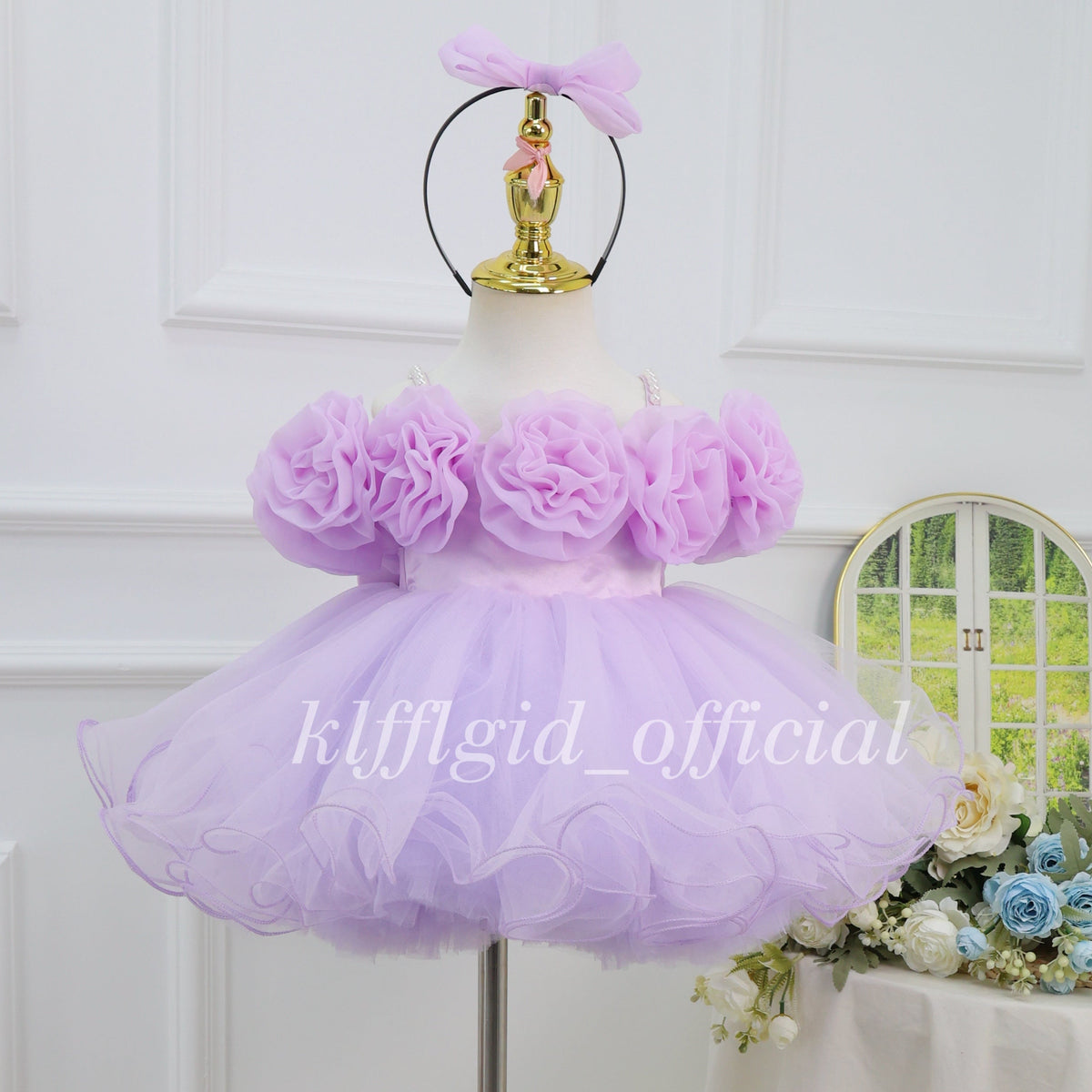 Front view of a lavender first birthday dress for girls with oversized 3D floral bodice decorations, a full layered tulle skirt, and a matching bow headband.