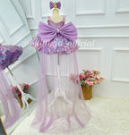 Back view of a lavender princess gown for girls with a large satin-look bow, sparkling embellished bodice, colorful floral skirt, and floor-length sheer tulle train.