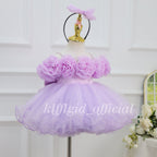 Three-quarter view of a lavender girls' birthday gown with oversized fabric flowers, a full flared skirt, and curled tulle edging.