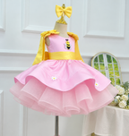 Three-quarter view of a pink bee-themed princess dress for girls with yellow shoulder accents, a bee appliqué, daisy details, and a voluminous layered skirt.