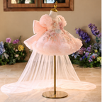 Pink floral princess dress for girls shown at an angle with puff sleeves, floral embroidery and flowing tulle train