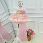 Pink floral flower girl dress shown at an angle with pastel flower embellishments, a full layered tulle skirt and a long pink train
