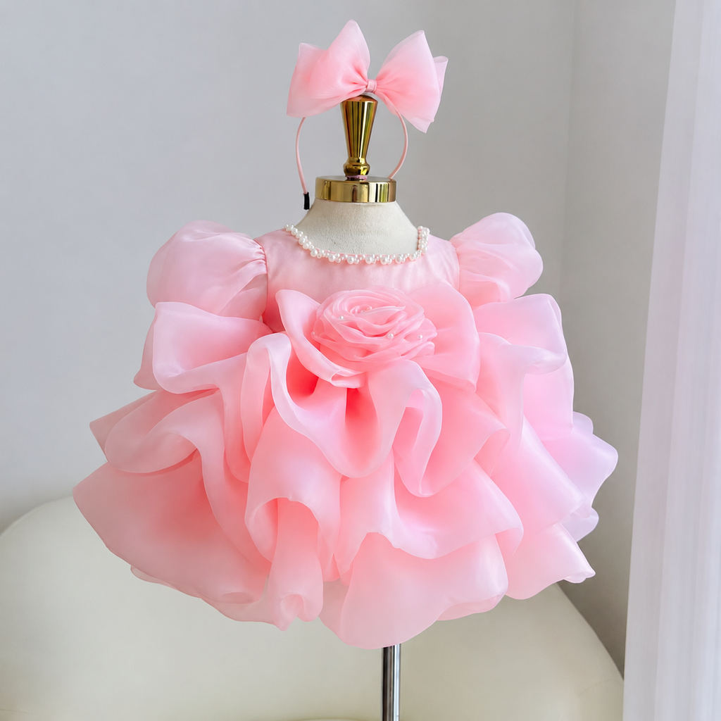 Pink girls princess dress with a dimensional rose bodice decoration, puff sleeves, layered ruffle skirt and matching pink bow