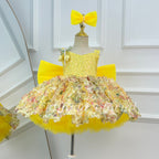 Yellow girls' princess dress featuring a sleeveless embellished bodice, multicolored floral skirt details, a full layered skirt, and a large matching yellow bow.